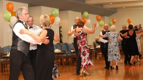 A group of holidaymakers sequence dancing